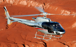 Вертолет AS350B3e летит над пустыней