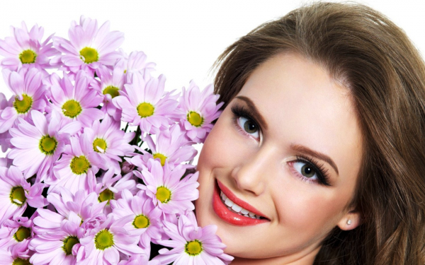 Красивая девушка с букетом ромашек