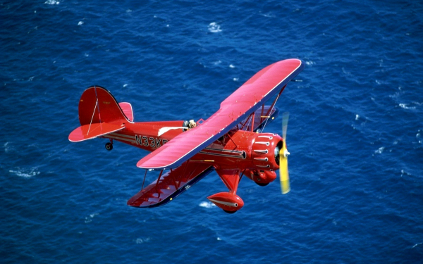 Биплан летит над морем