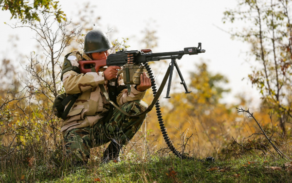 Солдат стреляет из пулемета
